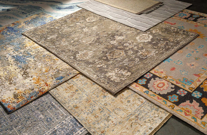 Close-up of various rugs, including the Dalupaon Area Rug, showcasing floral, oriental, and traditional patterns in beige, gray, and blue tones. Styleshot