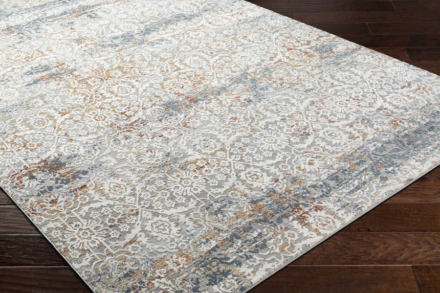 Close-up of the Marden Textured Luxe Area Rug showing its brick red, camel, and blue traditional pattern. Corner