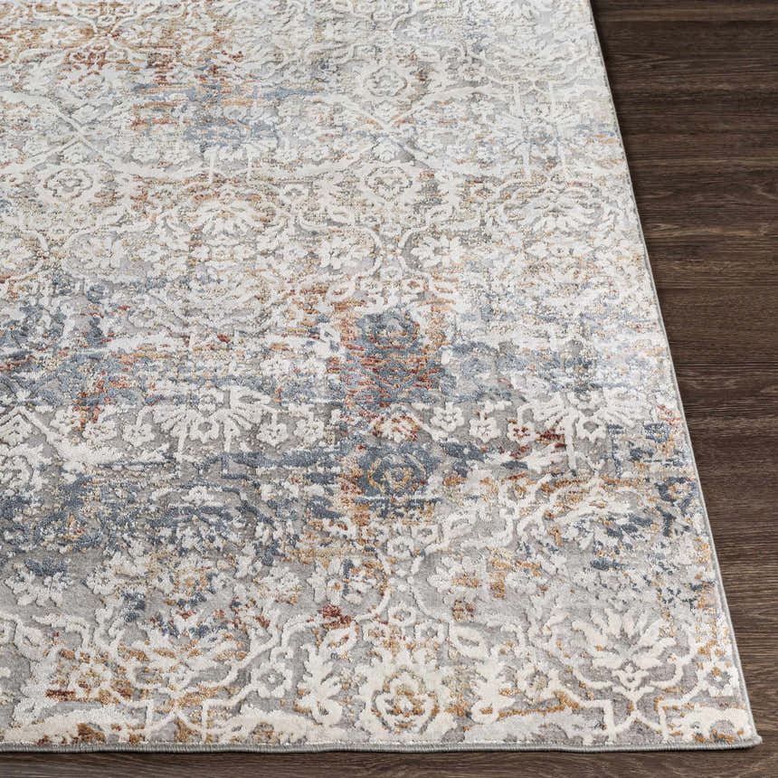 Close-up of the Marden Textured Luxe Area Rug showing brick red, camel, and gray floral pattern on dark wood floor. Front