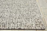 Close-up of Nourison Starlight Midnight rug showing its abstract black and ivory pattern and soft Luxcelle texture.