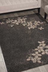 Living room scene with a Nourison Maxell Charcoal rug featuring taupe floral accents under a modern sofa.