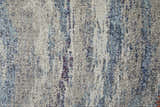 Close-up of Feizy Edgemont rug. Abstract design in blue, gray, and subtle orange hues. Jute, polyester, and polypropylene texture. Texture