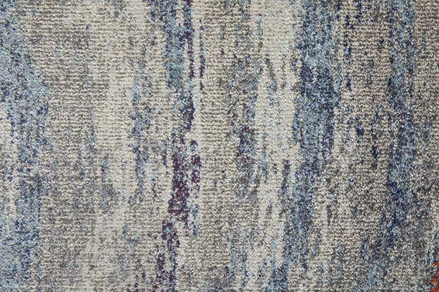 Close-up of Feizy Edgemont rug. Abstract design in blue, gray, and subtle orange hues. Jute, polyester, and polypropylene texture. Texture