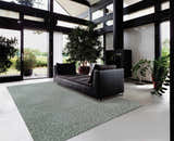 Modern living room with black sofa and Nourison Ambrose Slate Indoor Area Rug. Taupe wool rug with geometric pattern.