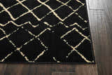 Close up of the Nourison Grafix Black Bohemian Indoor Area Rug showing its black and ivory geometric design.