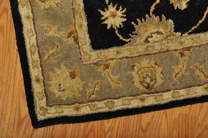 Close-up of the handmade Nourison India House Black Persian rug, showing wool texture and floral pattern.