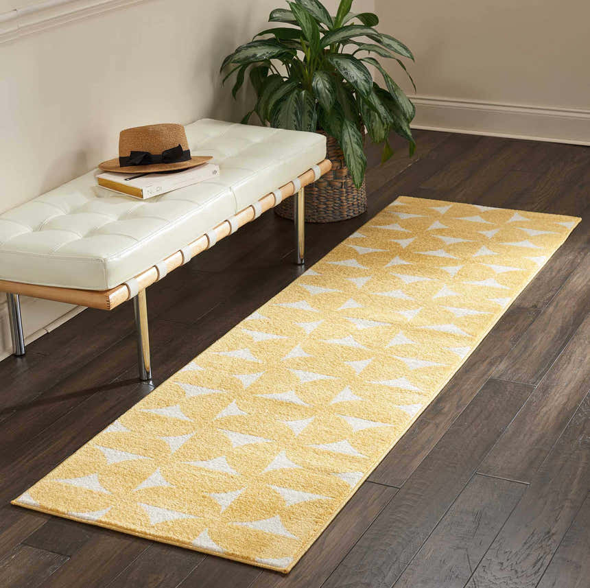 Entryway with white bench, plant, and Nourison Harper Yellow runner rug on dark wood floor.