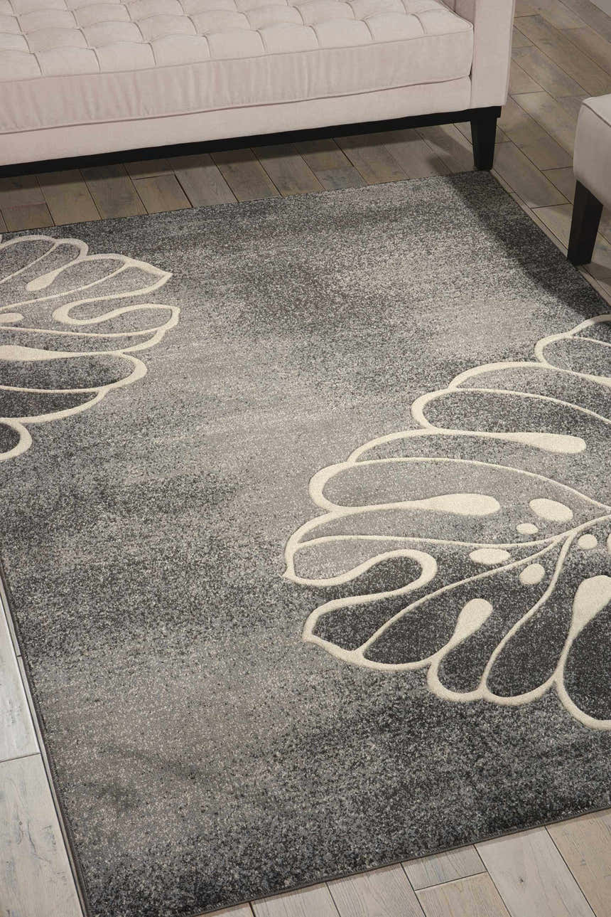 Living room scene with a grey Nourison Maxell rug featuring a large, abstract floral design in cream.