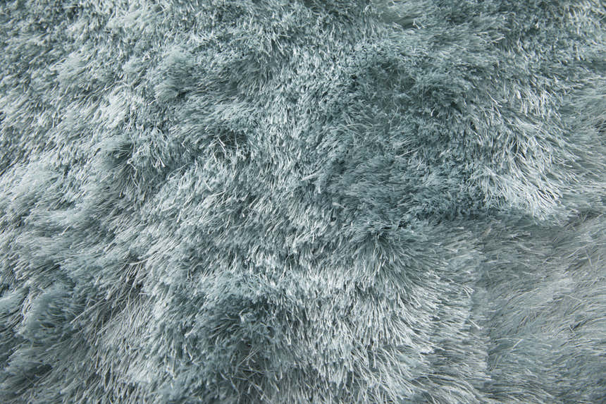 Close-up of the plush Feizy Indochine Modern Solid Area Rug in blue and silver gray, showing the soft, hand-tufted texture. Texture