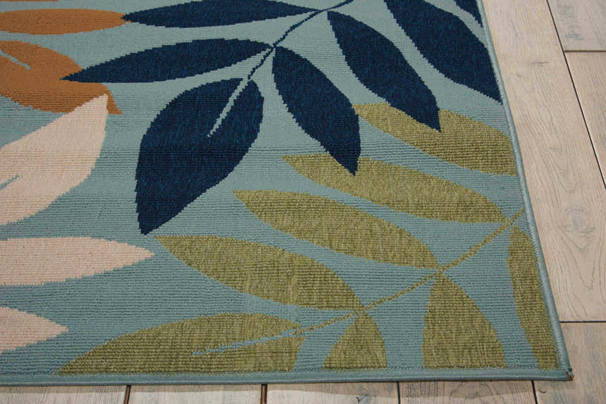 Close-up of Nourison Caribbean Blue Contemporary Area Rug with a leaf pattern in blue, green, tan, and cream.