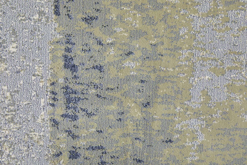 Close-up of Feizy Clio rug. Abstract design in blue, green, and ivory with textured, machine-made construction. Texture