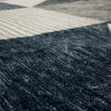 Close-up of the Karastan Oblique Blue Area Rug showing charcoal, cream, denim, and gray colors and contemporary design. Texture