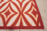 Close-up of Waverly Sun N' Shade Campari rug. Mid-century modern design in campari orange and white. Geometric pattern.