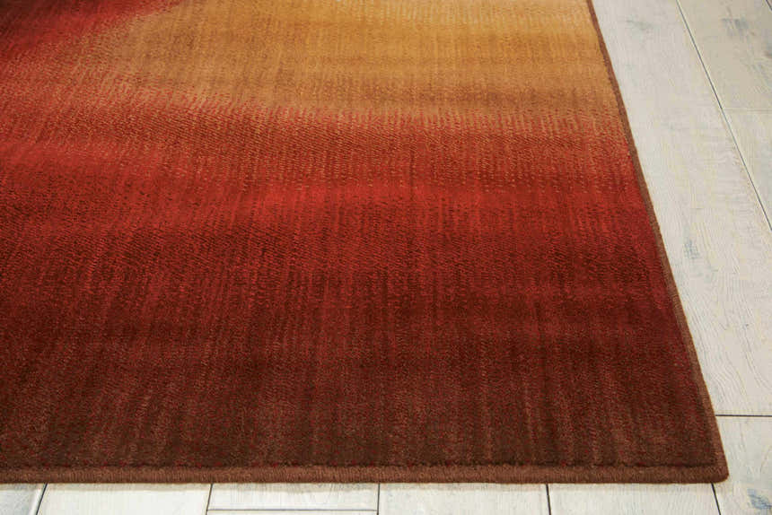 Close up of the Ruby Nourison Radiant Arts rug showing the texture and gradient of ruby red to gold.