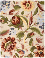 Close-up of Nourison Fantasy Ivory Floral rug. Chestnut, green, and blue floral pattern on a cream background.