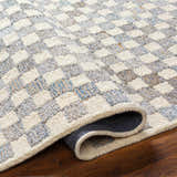 Close up of the Halen Gray Checkered Area Rug showing its geometric pattern, wool texture, and charcoal, gray, and natural colors. Fold