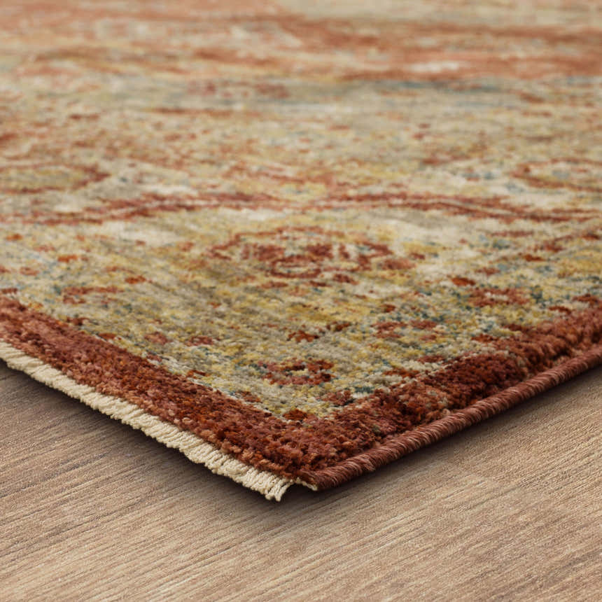 Close-up of the Karastan Palu Rust Area Rug showing its traditional design, rust border, and blended colors. Corner