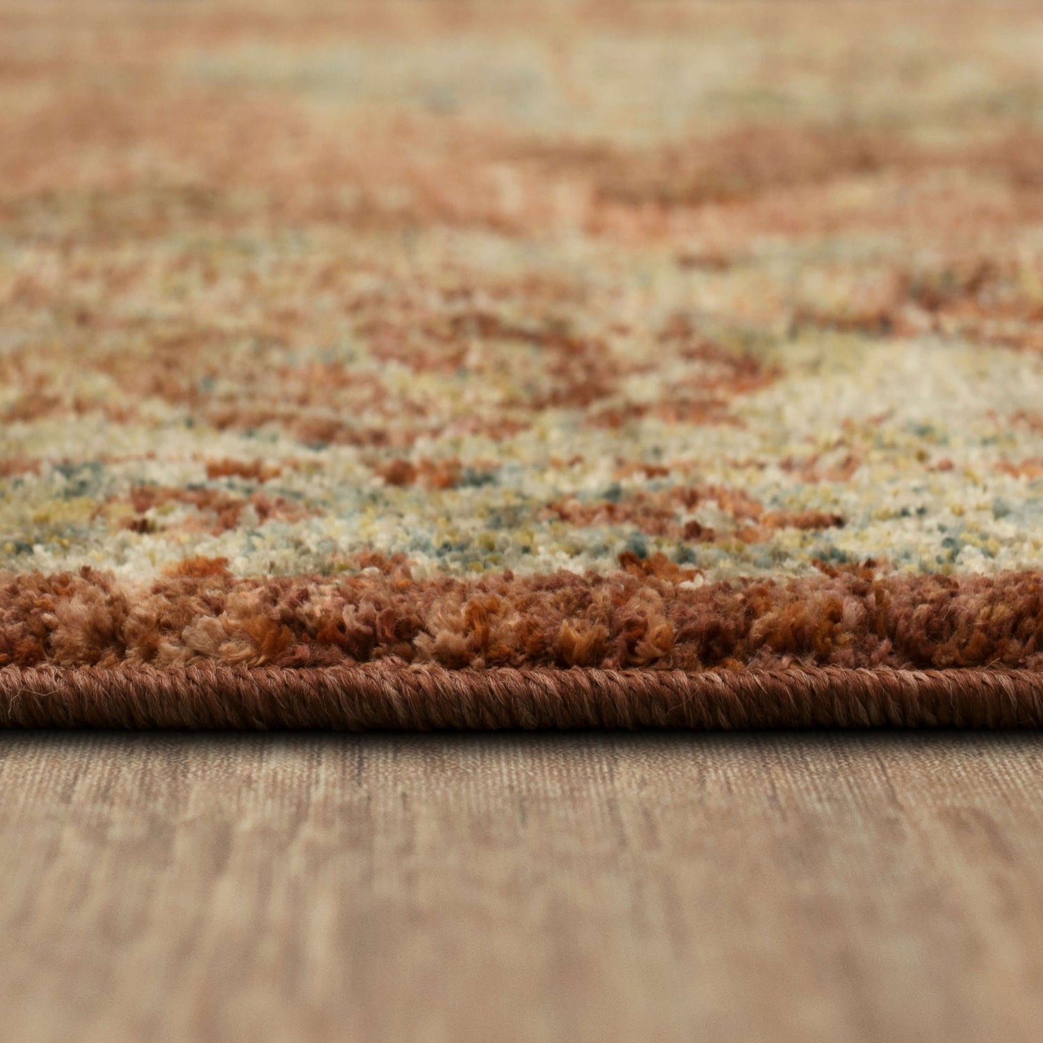 Close-up of the Karastan Palu Rust Area Rug showing its texture, colors (rust, blue, ivory, gray), and woven construction. Pile
