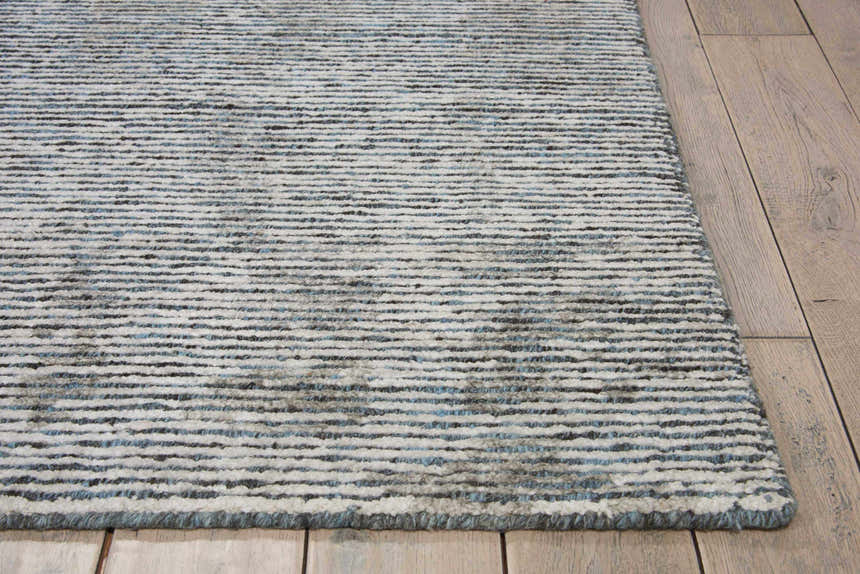 Close-up of the textured Nourison Ellora Slate Rug. Taupe, gray, and blue horizontal stripes on a handmade, mid-century modern rug.