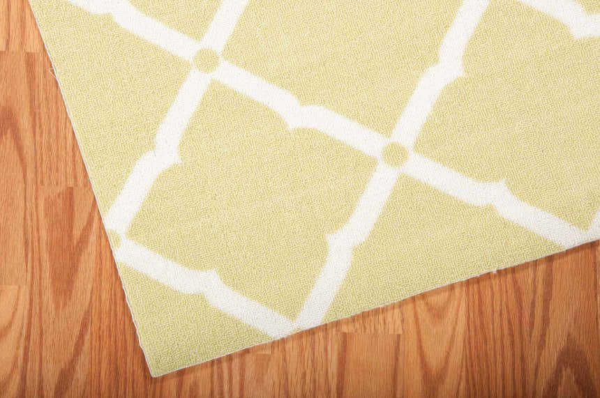 Close-up of the Nourison Home & Garden Light Green rug. Features a white geometric trellis pattern.