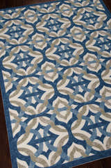 Close up of the Waverly Sun N' Shade Celestial Contemporary Area Rug, featuring blue and gray geometric patterns.