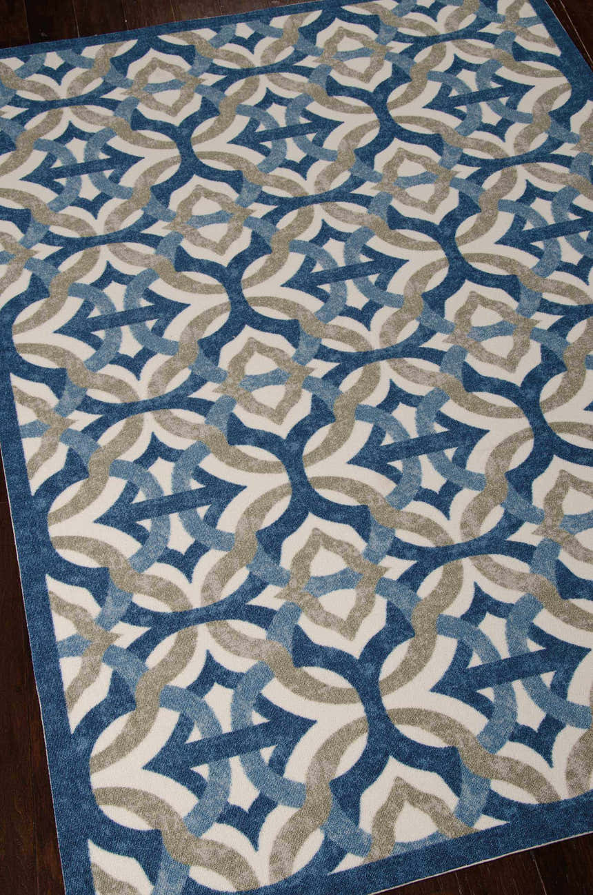 Close up of the Waverly Sun N' Shade Celestial Contemporary Area Rug, featuring blue and gray geometric patterns.