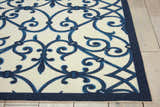 Close-up of Nourison Home & Garden Blue Farmhouse Area Rug. Ivory rug with a blue lattice and floral design.