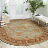 Bright sunroom with a light blue Nourison 2000 Persian rug, white bench, and plants.