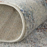 Close-up of the Feizy Edgemont rug showing its ivory, blue, and orange abstract pattern and textured weave. Fold
