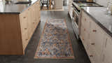 Kitchen scene with a Feizy Kaia Transitional Floral rug in blue, orange, and ivory on dark tile floor between wood cabinets. Roomscene-Runner