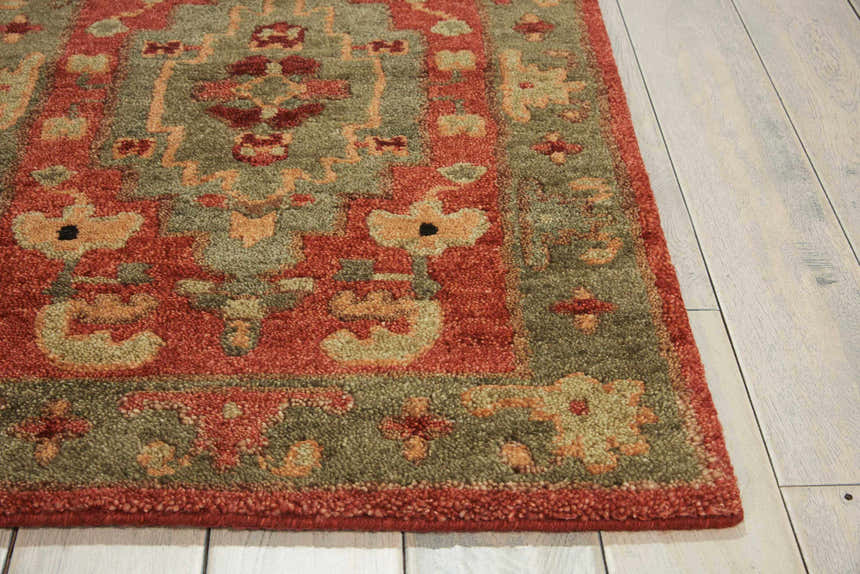Close up of the rust-colored Nourison Tahoe rug showing the traditional floral pattern and wool texture.