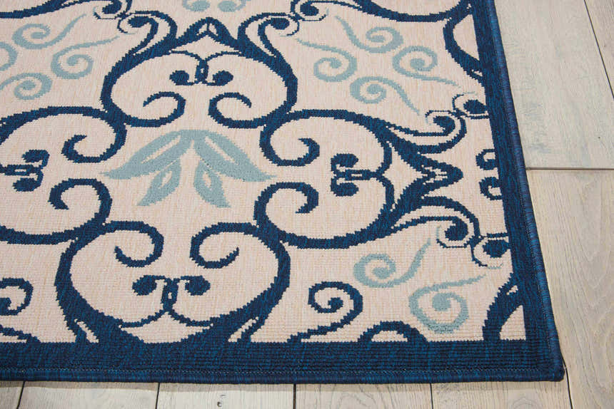 Close-up of Nourison Caribbean Ivory Navy rug featuring a blue floral and scroll pattern on a cream background.