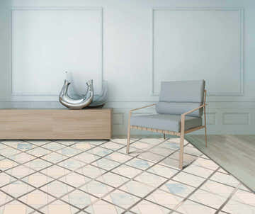 Living room scene with Barclay Butera Cooper Cloud rug, light wood floors, gray chair, and modern vases on a console table.