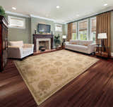Living room with sandstone Nourison Regal Persian rug, white sofa and armchair, fireplace, and hardwood floors.