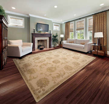 Living room with sandstone Nourison Regal Persian rug, white sofa and armchair, fireplace, and hardwood floors.