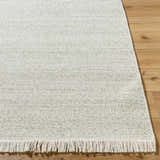 Close-up of the Sorell Sage textured weave rug showing ecru, ivory, and sage tones and fringe detail on wood floor. Front