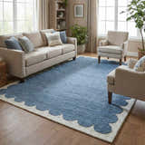 Living room with a Lukamu Modern Art Deco rug. Blue wool rug with ivory scalloped edge, beige sofa, and two armchairs. Roomscene-Rectangle