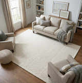 Beige living room with a cream sofa and the Kazuto Area Rug, a hand-tufted wool rug, adding a soft, contemporary feel. Roomscene-Rectangle