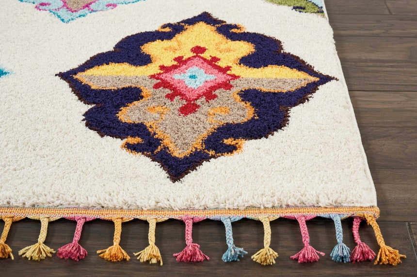 Close-up of the Nourison Nomad Ivory Multicolor Floral rug, showing the floral design and colorful tassels.