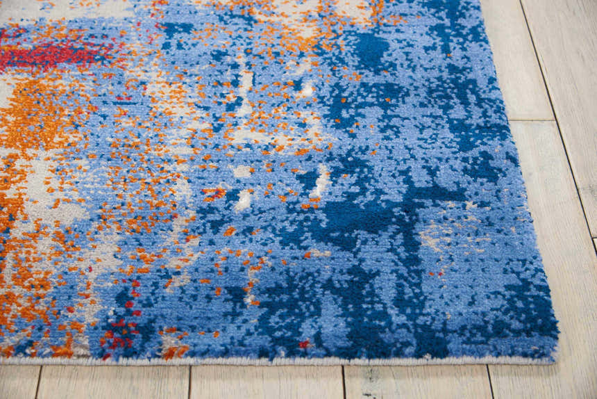 Close-up of Nourison Twilight Ivory Multicolor rug showing abstract chestnut, blue, and white pattern.