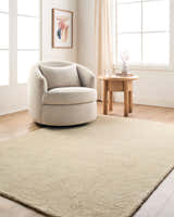 Living room scene with a beige swivel chair and The Neutral Edit Rachel Zoe x LIVABLISS RZNE-2302 Area Rug in sandstone. Roomscene-Rectangle