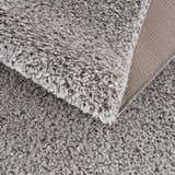 Close up of the plush texture and backing of the Lunaro Gray shag rug. Fold