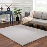 Living room scene with gray sofa and Lunaro Gray wavy abstract rug on wood floor. Roomscene-Rectangle