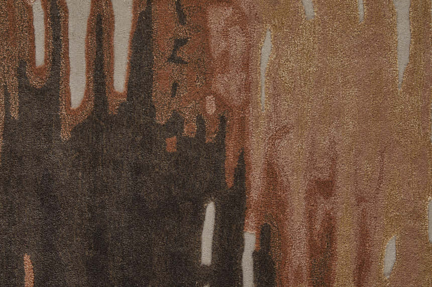 Close-up of Feizy Anya rug. Abstract design in dark red, orange, brown, and gray tones. Hand-tufted texture. Texture