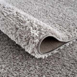 Close-up of the plush, gray Lunaro shag rug. Soft polyester fibers create a subtle wavy texture. Fold