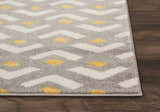 Close-up of Nourison Harper Grey Colorful rug showing geometric pattern in gray, white, and yellow on a wood floor.