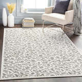 Living room scene with a Seascale Outdoor Carpet featuring a gray animal print, light walls, and a neutral armchair. Roomscene-Rectangle