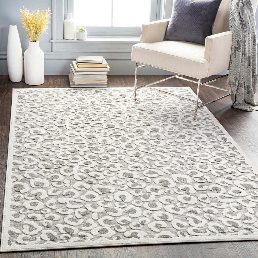 Living room scene with a Seascale Outdoor Carpet featuring a gray animal print, light walls, and a neutral armchair. Roomscene-Rectangle