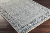Close-up of the hand-knotted Sherwood Area Rug. Ice blue, ink blue, and teal colors with a traditional geometric pattern. Corner