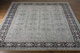 Close-up of the hand-knotted Sherwood Area Rug. Ice blue wool rug with ink blue, teal, and ivory traditional geometric patterns. Front